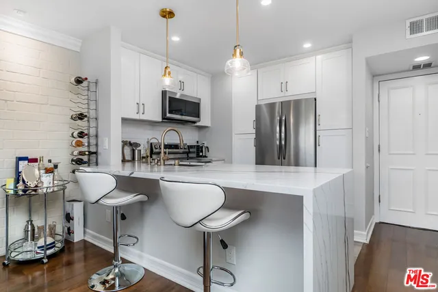 a kitchen with stainless steel appliances granite countertop a sink refrigerator and cabinets