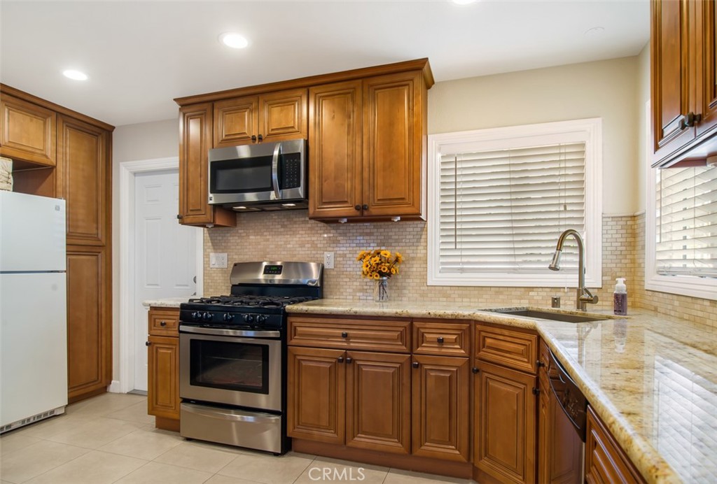 7192 9th Street Buena Park, CA 90621 - Photo 7 of 24 a kitchen with granite countertop a sink a stove and cabinets