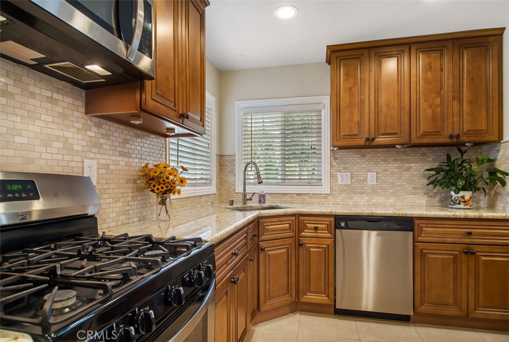 7192 9th Street Buena Park, CA 90621 - Photo 9 of 24 a kitchen with wooden cabinets and a stove top oven