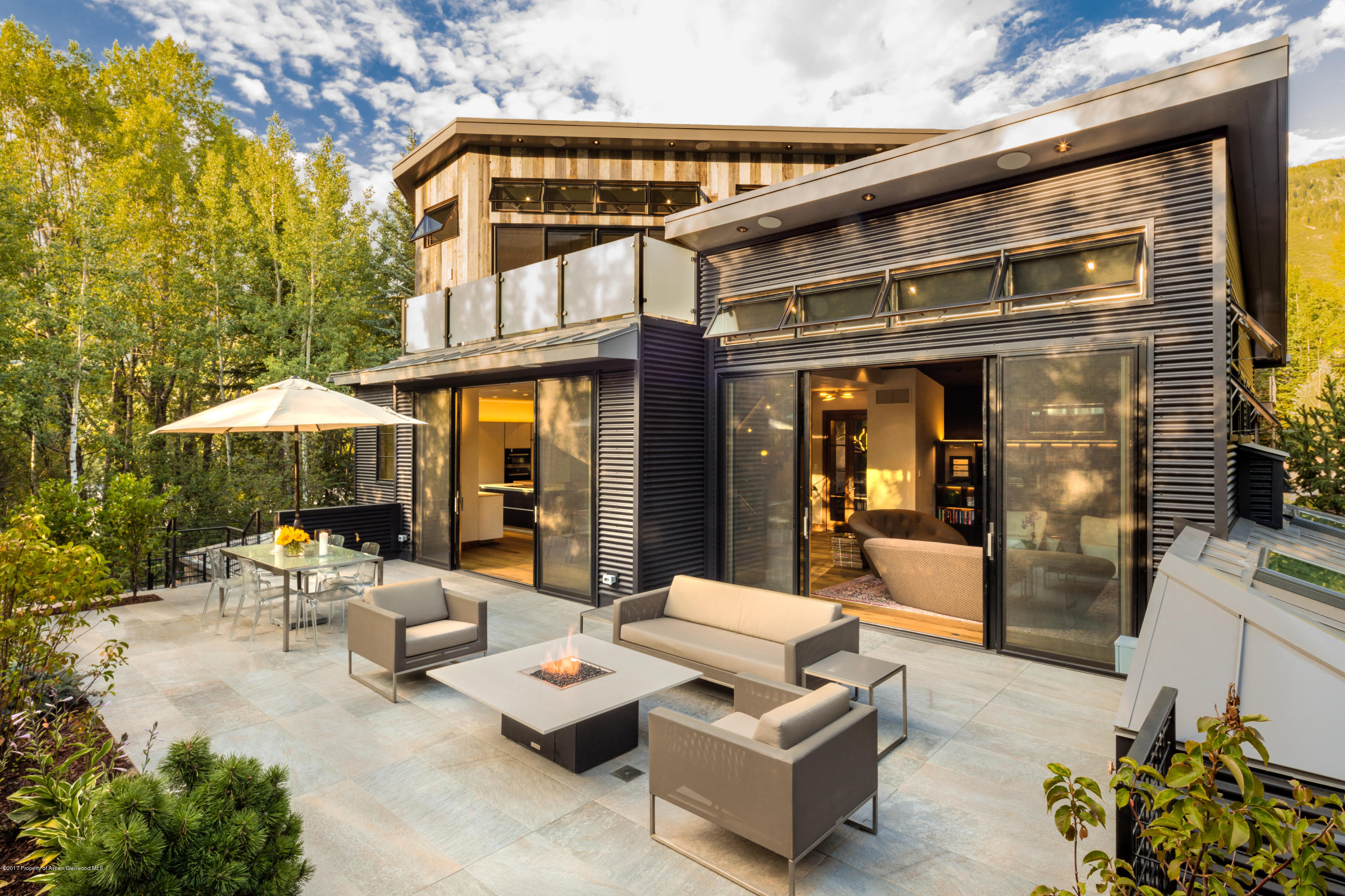 a view of a patio with dining table and chairs under an umbrella