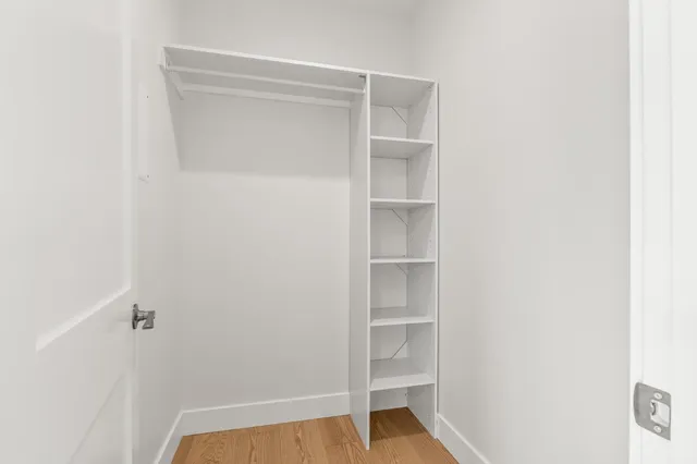a view of walk in closet with empty racks