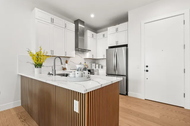 a kitchen with stainless steel appliances granite countertop a sink a refrigerator and a granite counter tops