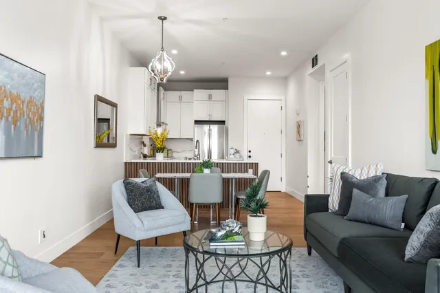 a living room with furniture a dining table and a chandelier