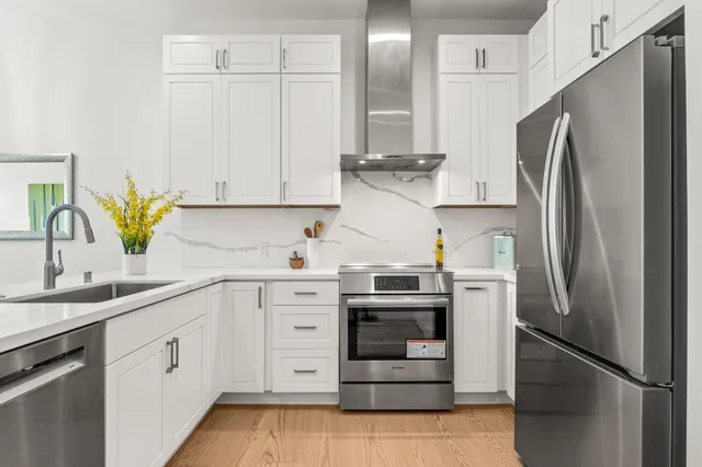 a kitchen with stainless steel appliances granite countertop a refrigerator sink and stove