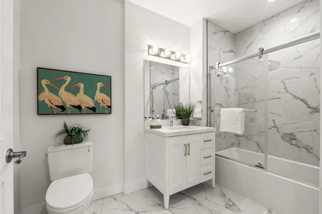 a white toilet sitting next to a bathroom sink and tub