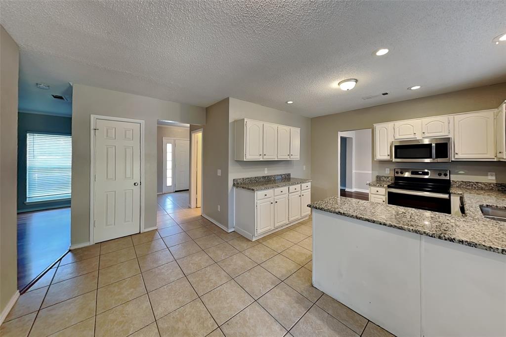 604 Ashby Place Allen, TX 75002 - Photo 5 of 21 a large kitchen with stainless steel appliances granite countertop a stove a sink and a refrigerator