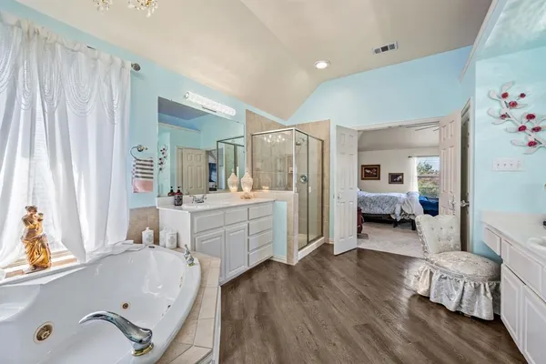 a bathroom with a tub sink and mirror