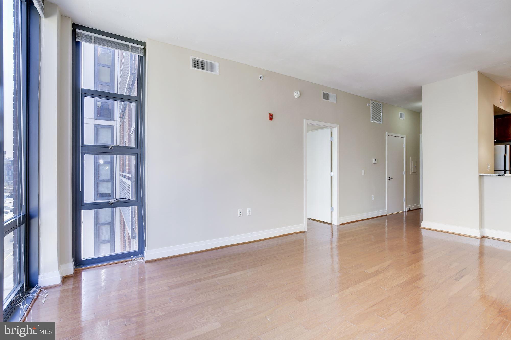 2120 Vermont Avenue Northwest, Unit 402 Washington, DC 20001 - Photo 11 of 41 a view of an empty room with wooden floor and a window