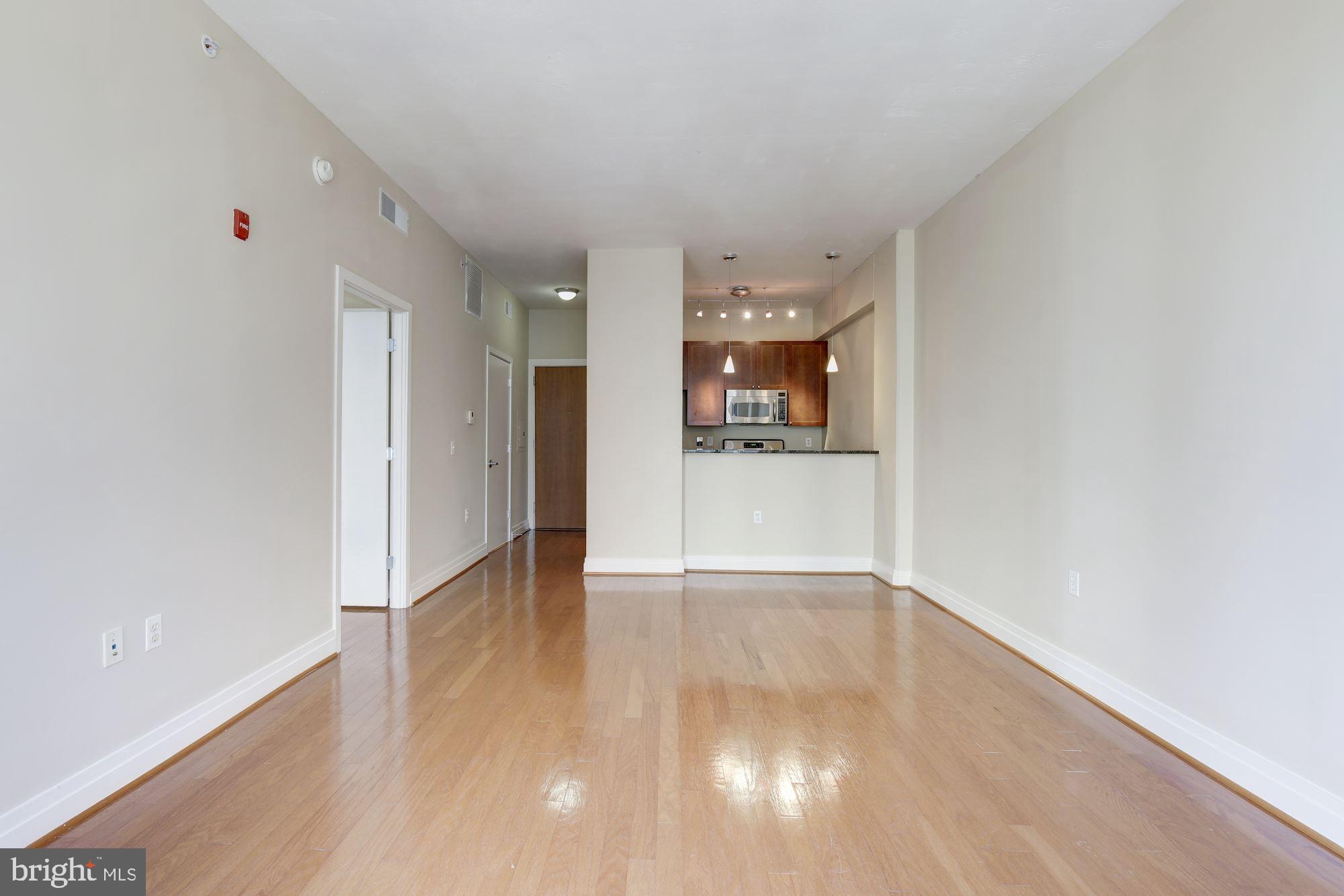 2120 Vermont Avenue Northwest, Unit 402 Washington, DC 20001 - Photo 12 of 41 a view of a hallway with wooden floor and a refrigerator