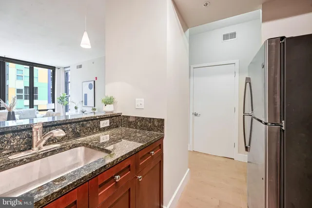 a bathroom with a granite countertop double vanity sink and mirror