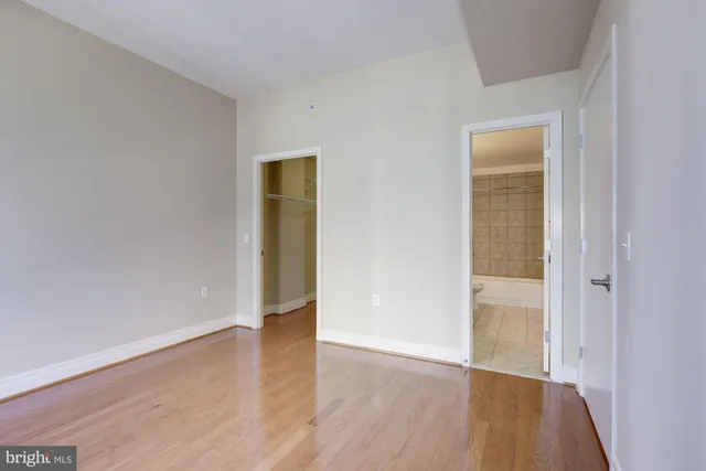 an empty room with wooden floor and closet