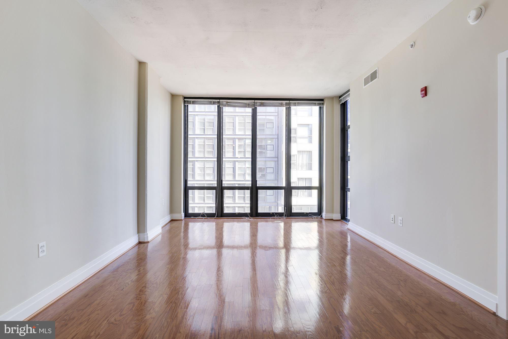 2120 Vermont Avenue Northwest, Unit 402 Washington, DC 20001 - Photo 5 of 41 a view of an empty room with wooden floor and a window