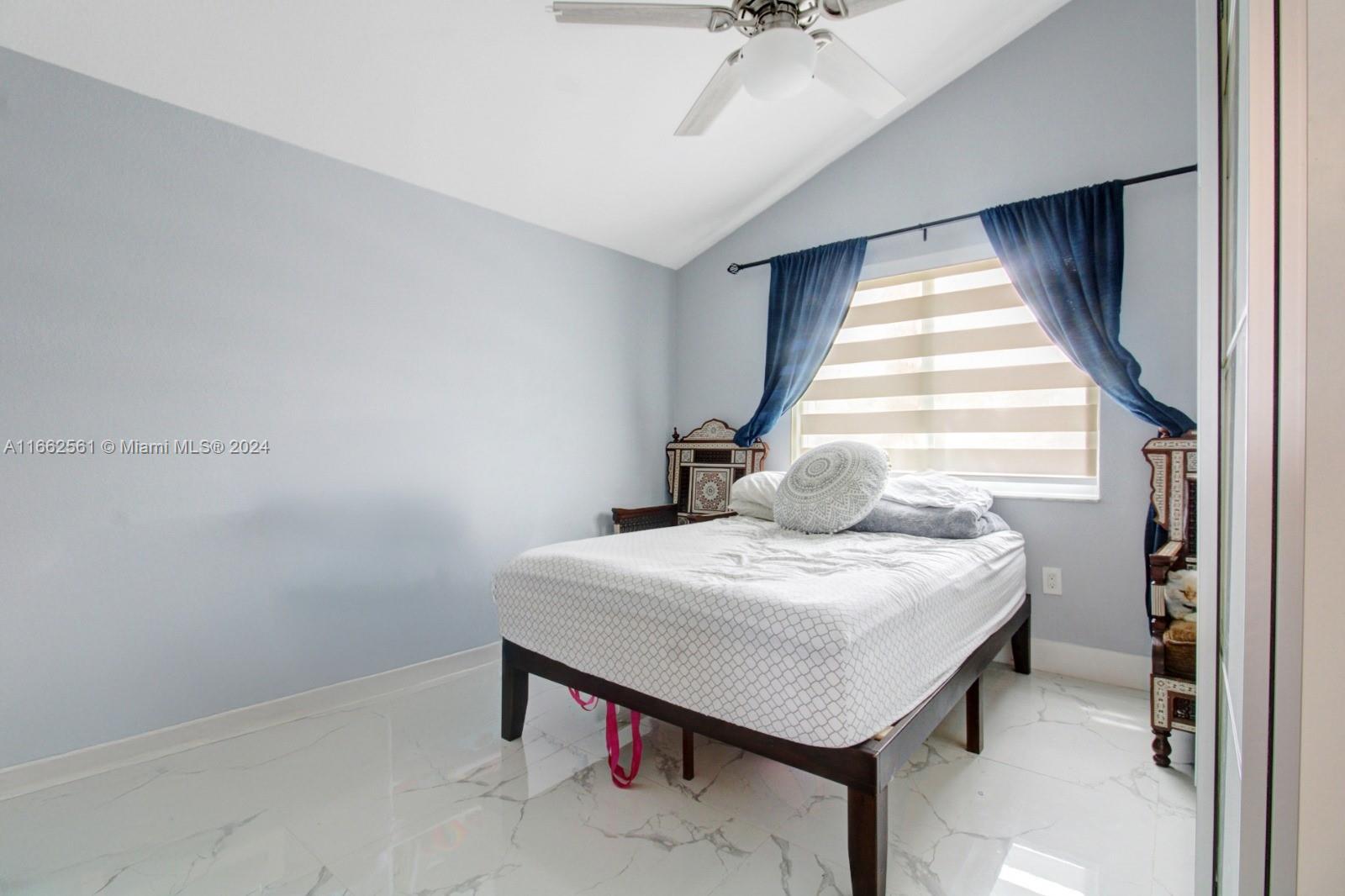 13505 Southwest 119th Street Miami, FL 33186 - Photo 18 of 25 a bedroom with a bed and a chandelier