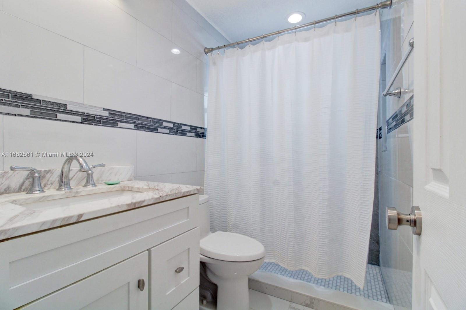 13505 Southwest 119th Street Miami, FL 33186 - Photo 19 of 25 a bathroom with a granite countertop sink toilet and shower