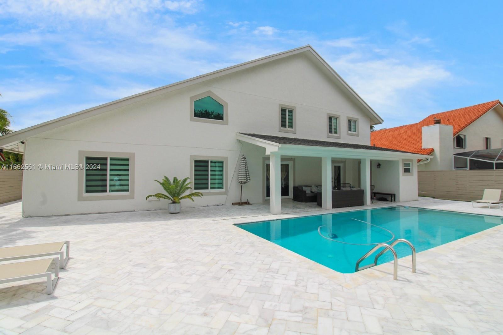 13505 Southwest 119th Street Miami, FL 33186 - Photo 2 of 25 a view of a white house with a swimming pool
