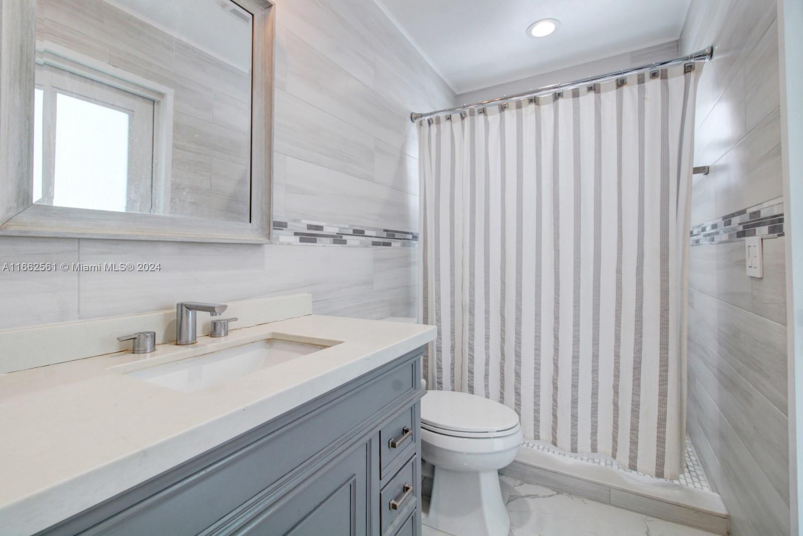 13505 Southwest 119th Street Miami, FL 33186 - Photo 21 of 25 a bathroom with a sink a toilet and shower curtain