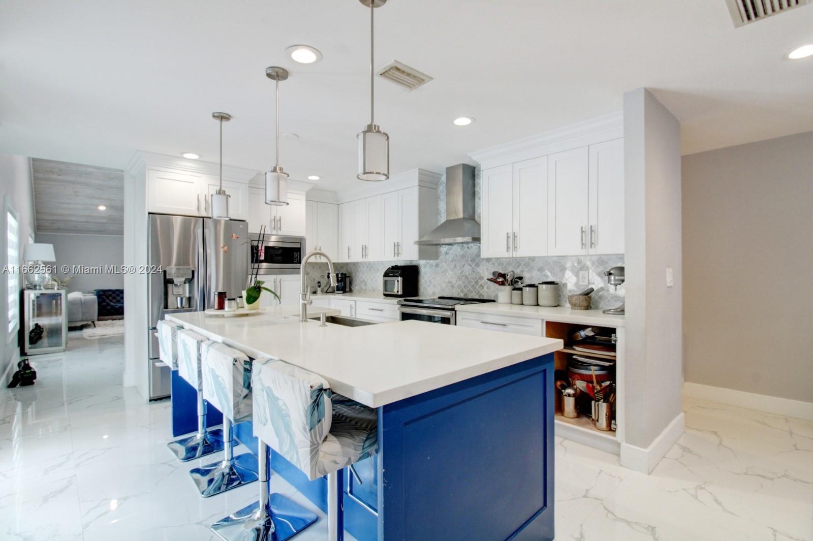 13505 Southwest 119th Street Miami, FL 33186 - Photo 8 of 25 a large kitchen with kitchen island a sink table and chairs