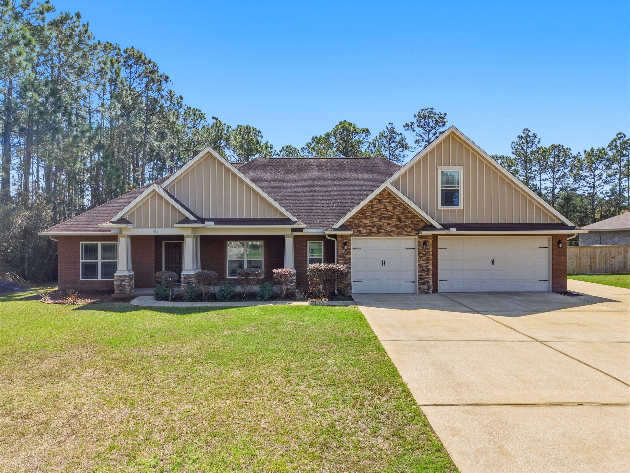 7151 Reef Street Navarre, FL 32566 - Photo 1 of 52 a front view of a house with a garden and yard