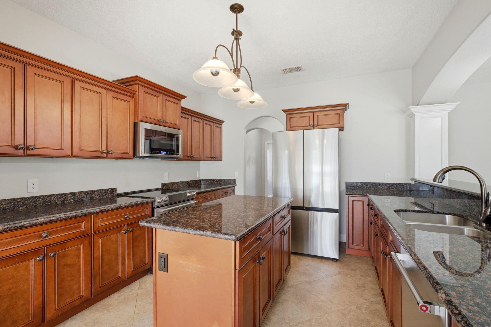 7151 Reef Street Navarre, FL 32566 - Photo 19 of 52 a kitchen with stainless steel appliances granite countertop a sink stove microwave and refrigerator