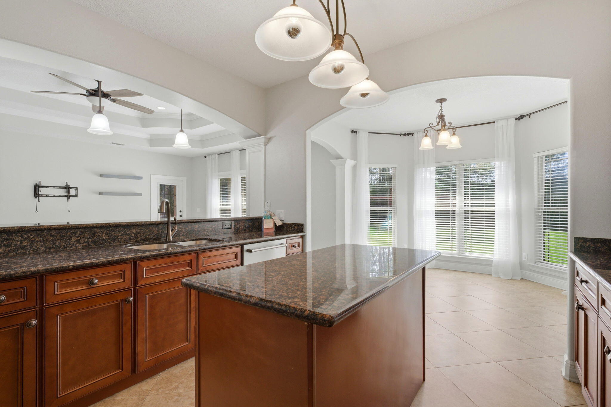 7151 Reef Street Navarre, FL 32566 - Photo 21 of 52 an open kitchen with granite countertop a sink and dishwasher with wooden floor