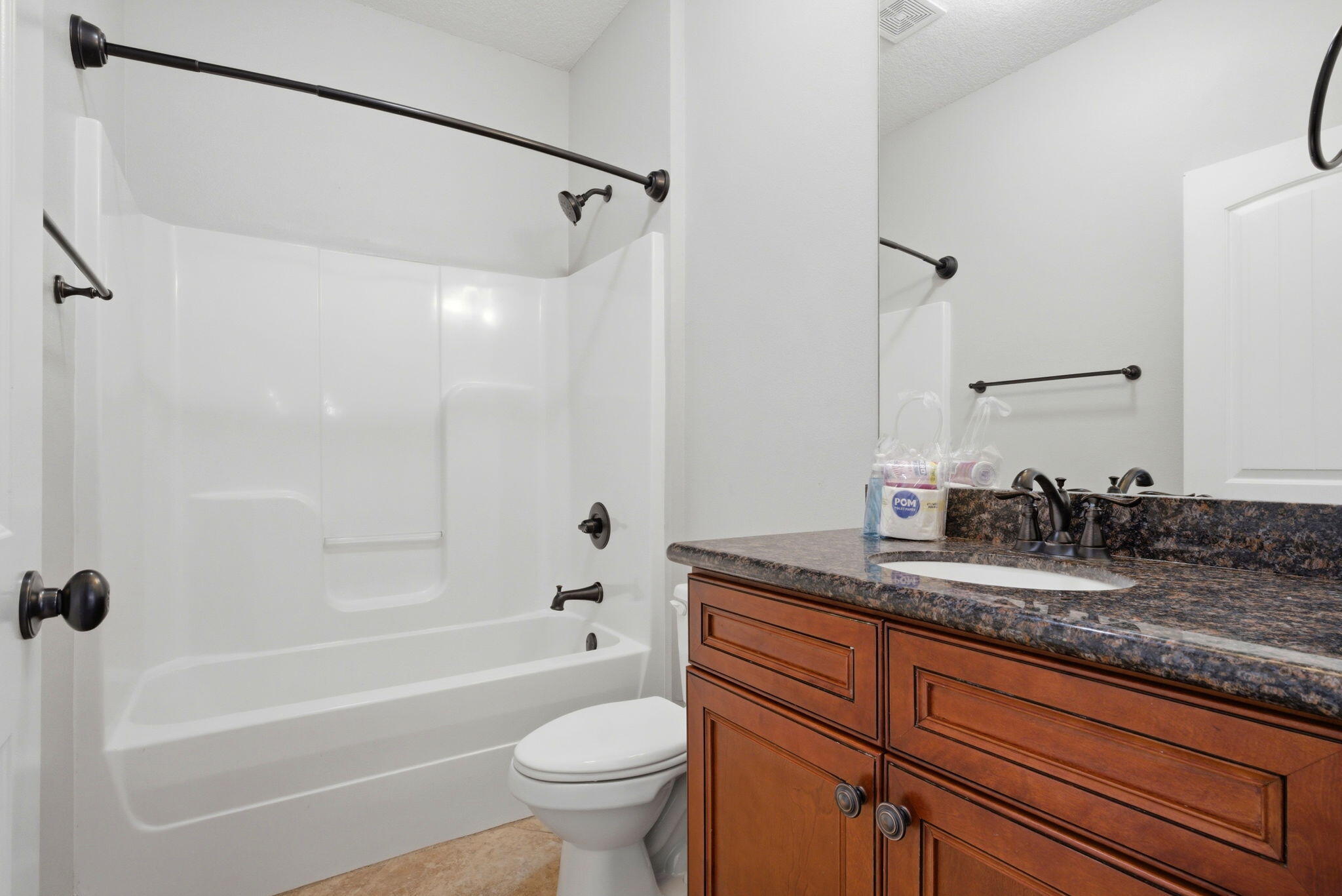 7151 Reef Street Navarre, FL 32566 - Photo 25 of 52 a bathroom with a granite countertop sink toilet mirror and bathtub