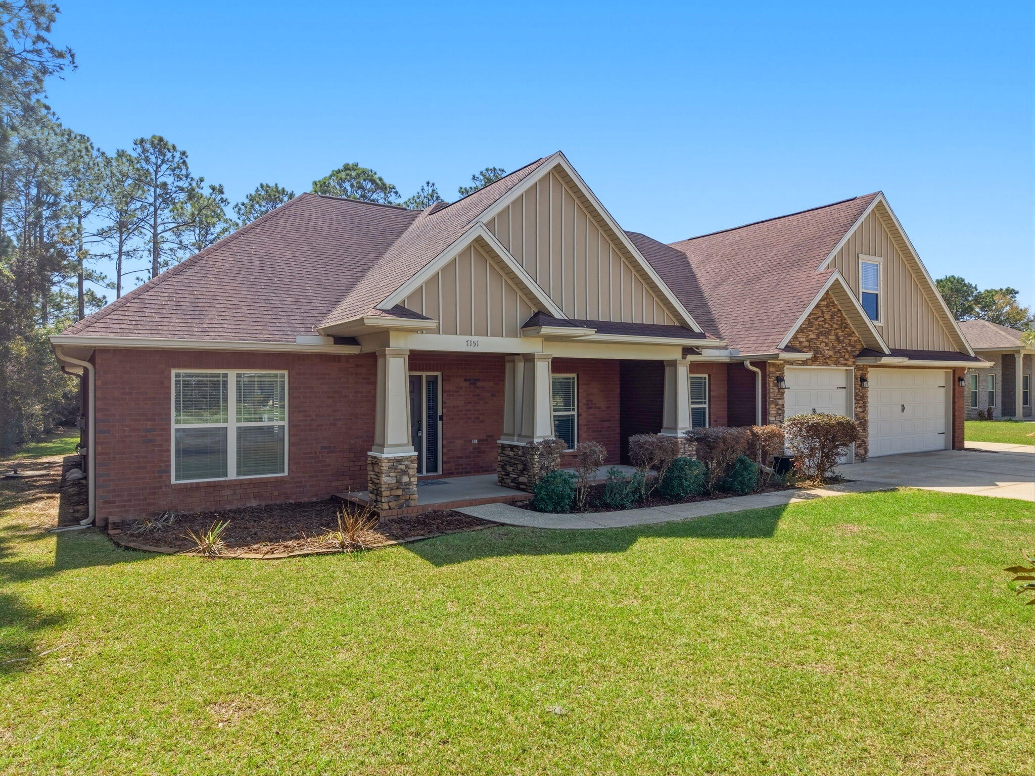 7151 Reef Street Navarre, FL 32566 - Photo 4 of 52 a front view of a house with a garden and patio