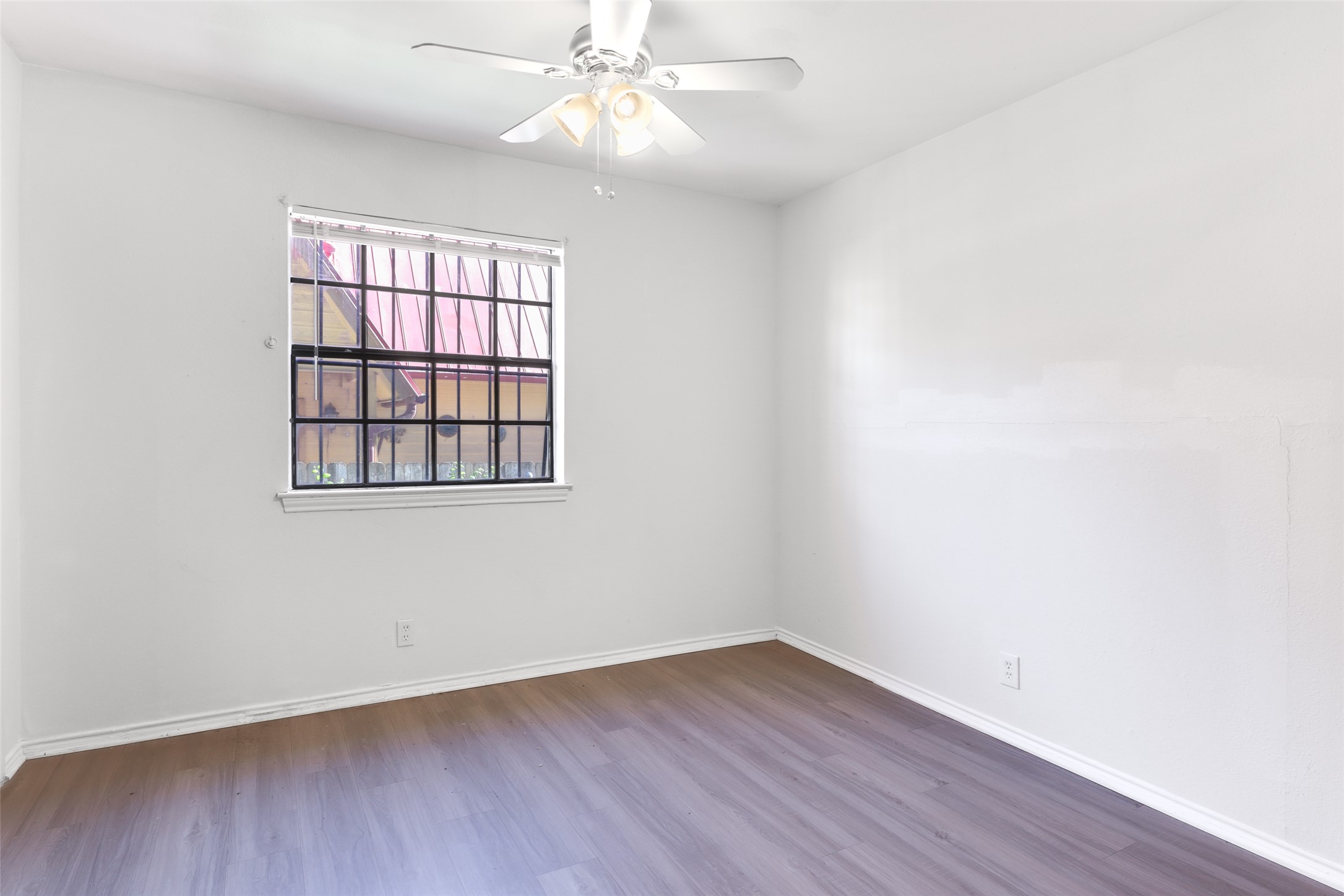 1903 East 20th Street Austin, TX 78722 - Photo 10 of 13 an empty room with wooden floor fan and windows
