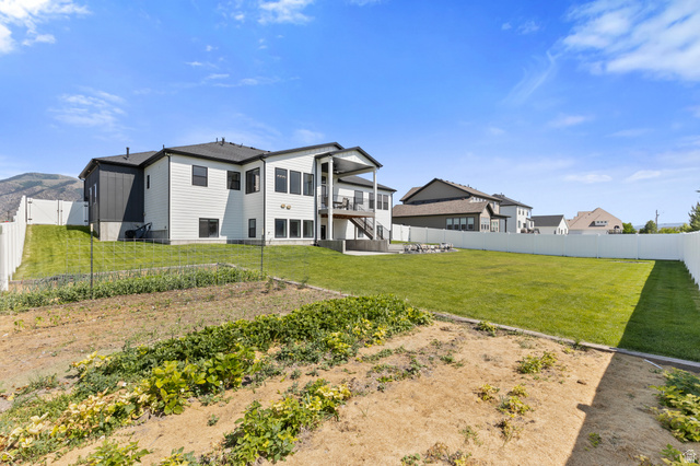 3111 South 1250 West Logan, UT 84321 - Photo 43 of 51 Expansive rear yard featuring a large grass lawn, dedicated garden area, and full privacy fencing