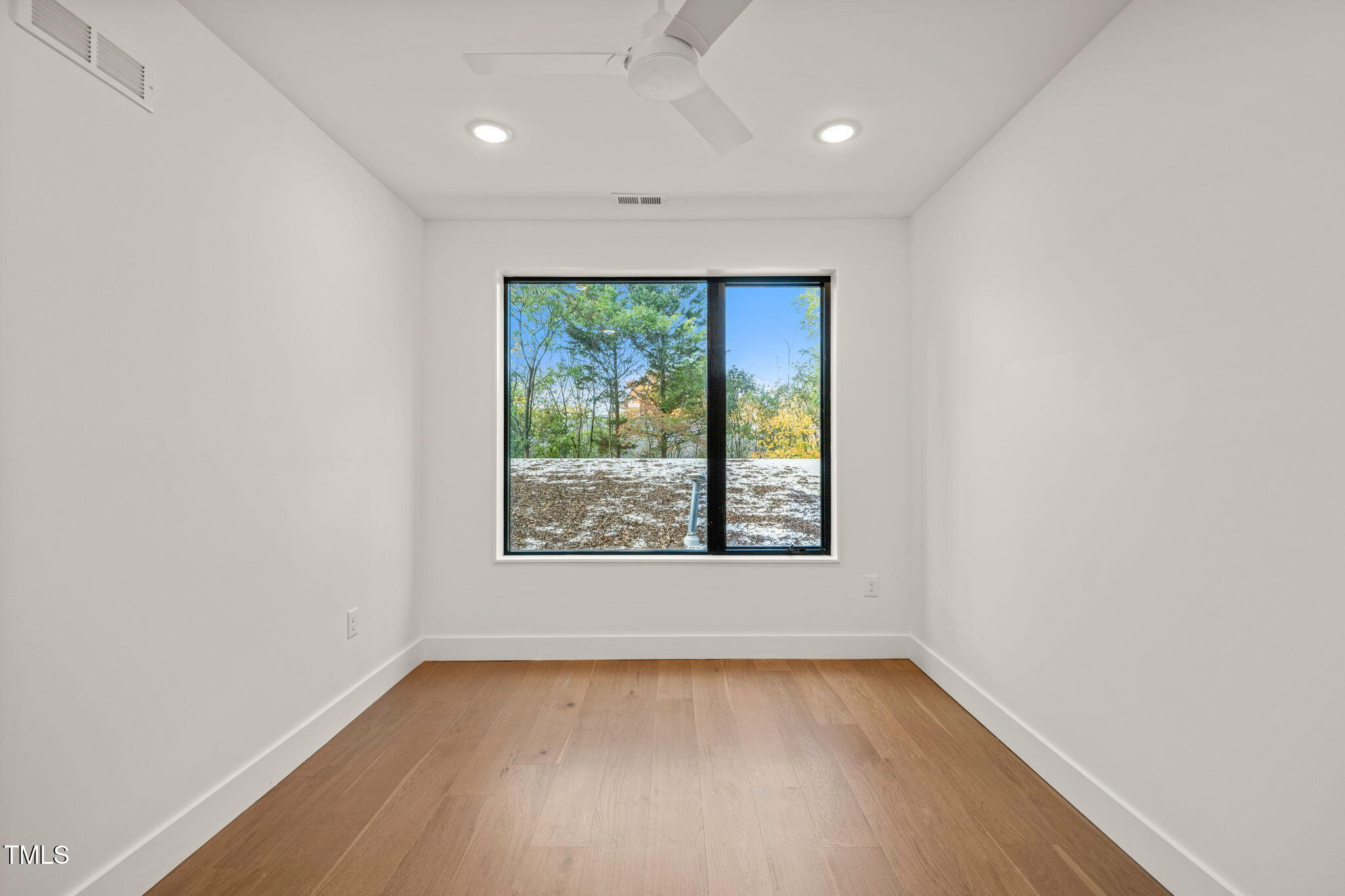 29 Enterprise Street, Unit 209 Raleigh, NC 27607 - Photo 19 of 46 an empty room with wooden floor and windows