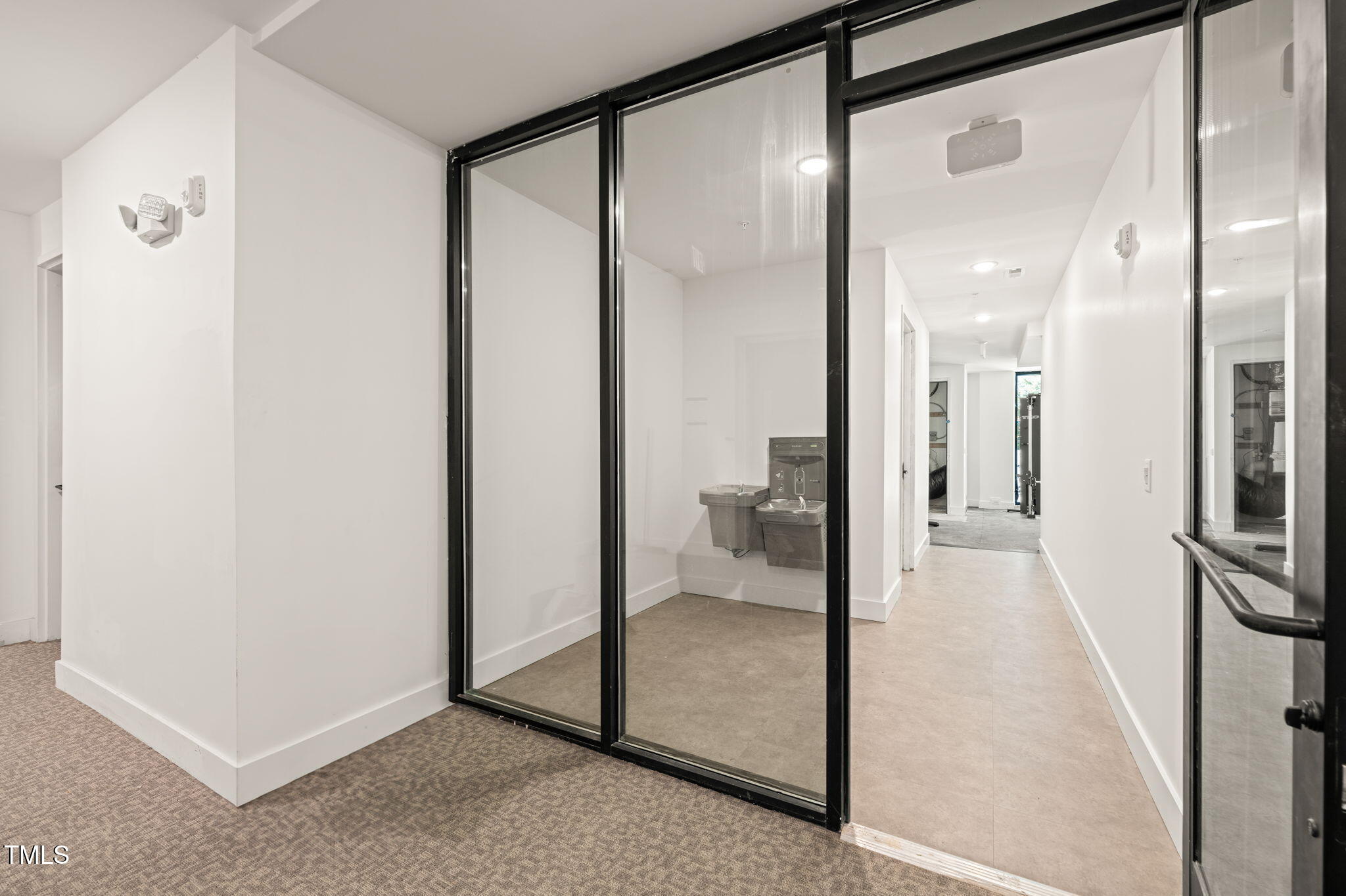 29 Enterprise Street, Unit 209 Raleigh, NC 27607 - Photo 29 of 46 a bathroom with a glass shower door and a mirror