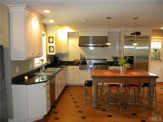 2615 Churchill Road Raleigh, NC 27608 - Photo 11 of 25 The kitchen layout is very functional for cooking and great for entertaining. The large wooden table is a family treasure and does not convey.