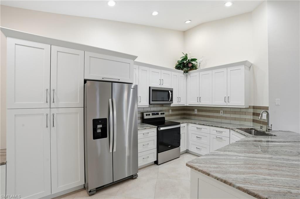 3724 Stone Way Estero, FL 33928 - Photo 14 of 35 Kitchen featuring light stone countertops, appliances with stainless steel finishes, white cabinets, and recessed lighting