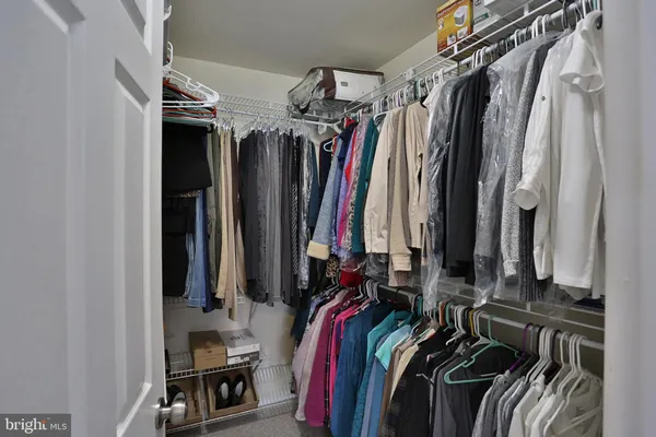 a view of walk in closet with clothes