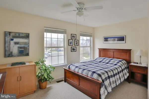 a large bed sitting in a bedroom next to a window and a dresser