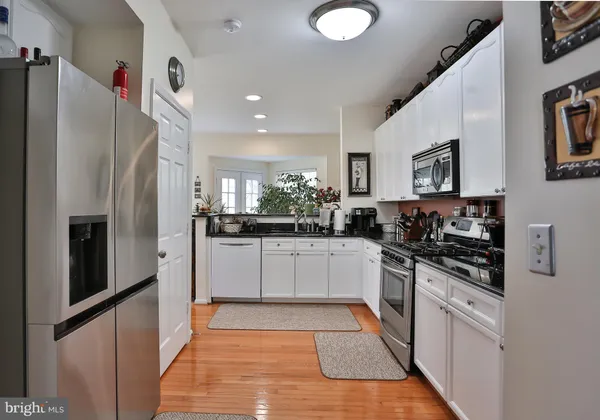 a large kitchen with stainless steel appliances granite countertop a refrigerator a stove and a sink