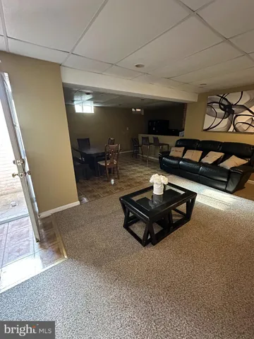a living room with furniture gym equipment and a rug