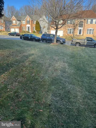 a view of a house with a big yard and large trees