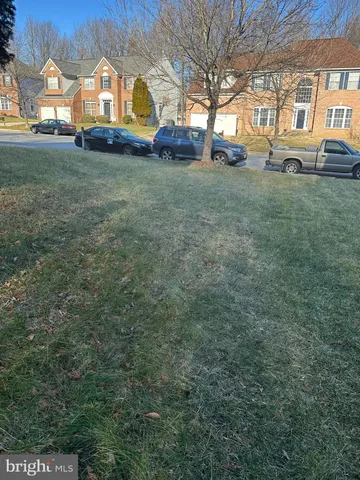 a view of a house with a big yard and large trees