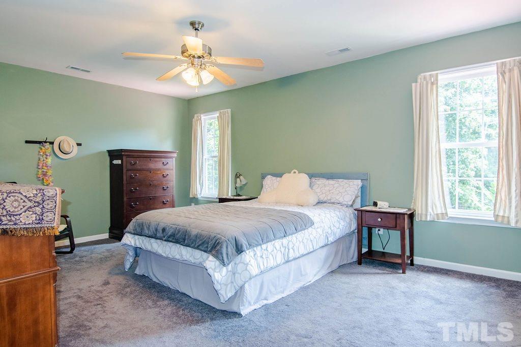 1224 Red Brick Road Garner, NC 27529 - Photo 13 of 30 a spacious bedroom with a bed and a chandelier