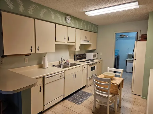 a kitchen that has a sink a stove and chairs