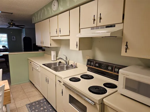 a kitchen with a sink a stove and cabinets