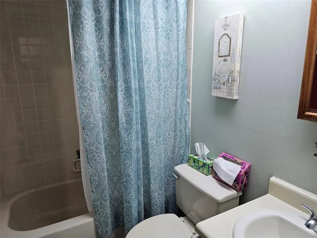 a white toilet sitting next to a shower curtain