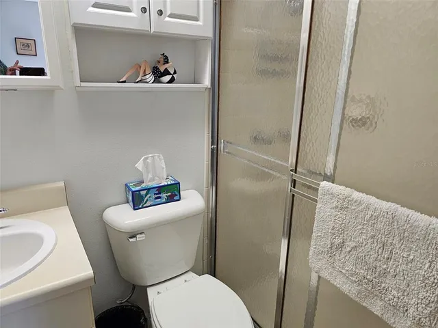 a white toilet sitting next to a bathroom sink and vanity