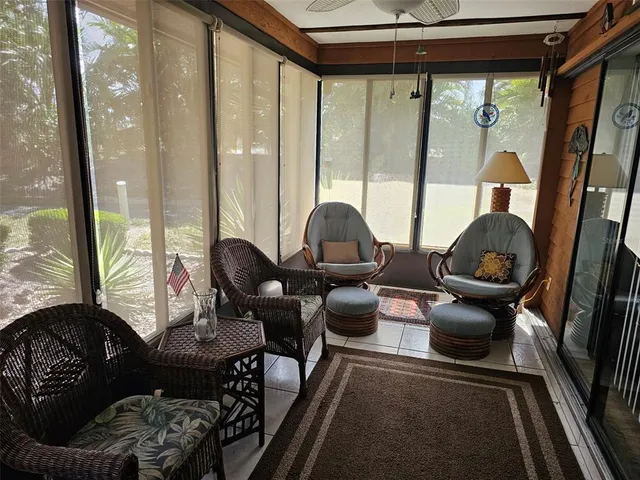 a living room with furniture and a floor to ceiling window