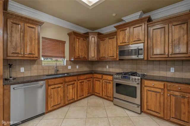 a kitchen with stainless steel appliances granite countertop a stove sink microwave and cabinets