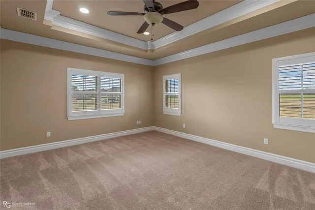 en empty room with windows and ceiling fan