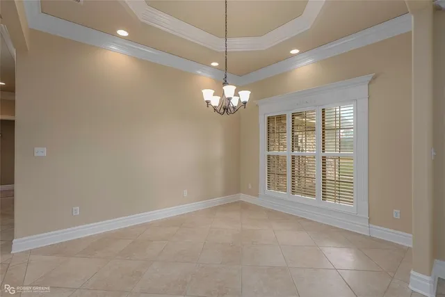 a view of a livingroom with a chandelier fan and windows