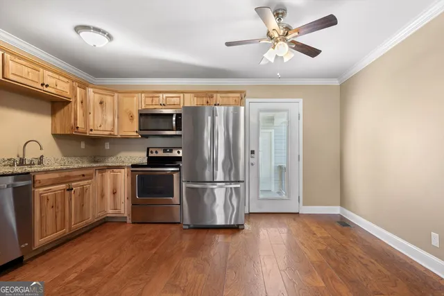 a kitchen with stainless steel appliances granite countertop a stove a sink and a refrigerator