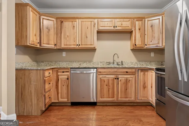 a kitchen with granite countertop stainless steel appliances a sink and cabinets