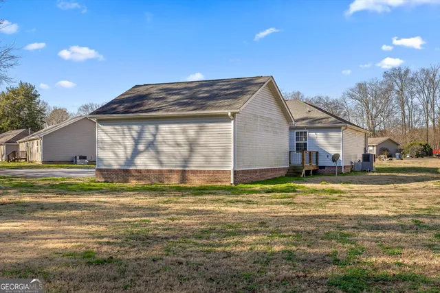 a view of a house with a yard and sitting area